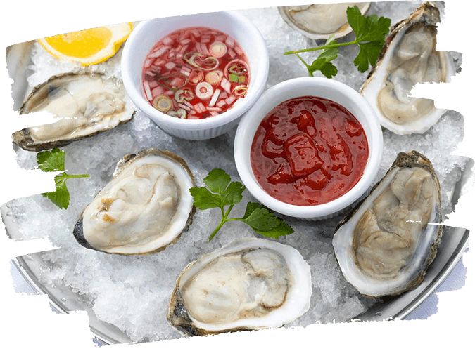 Fresh oysters on ice served with cocktail sauce and mignonette in white ramekins